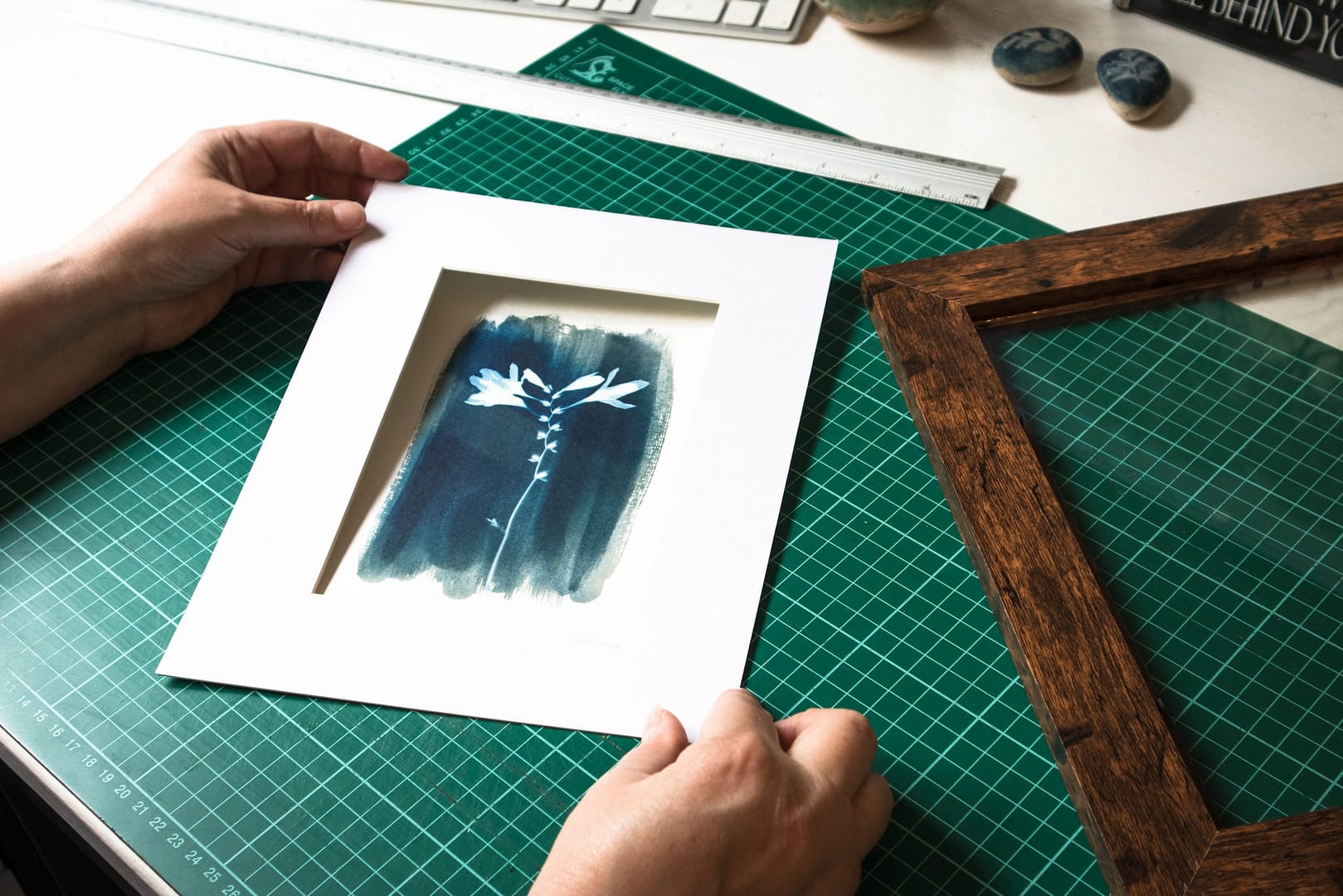 Cyanotype print being placed inside a mount for framing